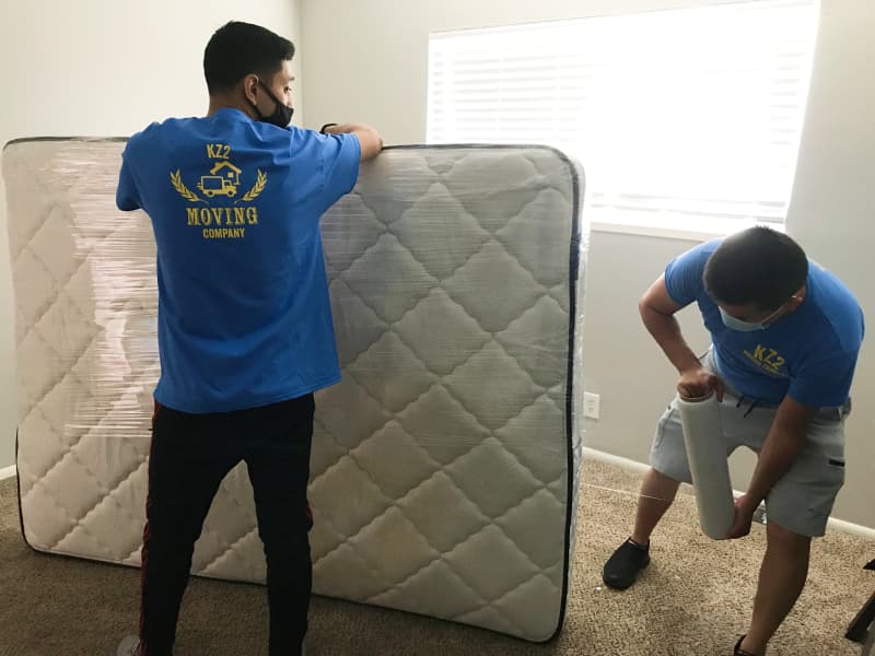 KZ2 movers wrapping a mattress