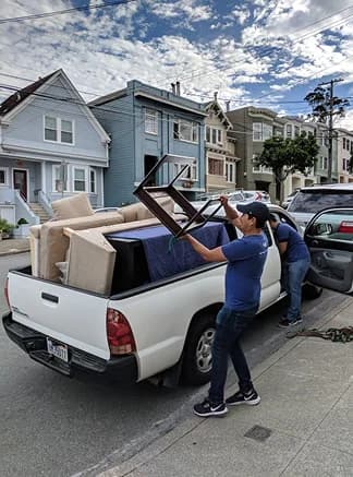 Luggers loading furniture on a pickup truck